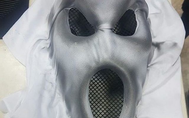Un masque effrayant porté par un garçon de 13 ans pour effrayer les passants, à Jérusalem, le 12 octobre 2017 (Crédit : Police israélienne) Un masque effrayant porté par un garçon de 13 ans pour effrayer les passants, à Jérusalem, le 12 octobre 2017 (Crédit : Police israélienne)