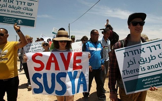 3 Palestiniens, des étrangers et des pacifistes israéliens manifestent dans le village de Sussiya au sud de la Cisjordanie contre la démolition du village palestinien dans les collines d'Hébron, le 5 juin 2015. (AFP / Hazem Bader) 3 Palestiniens, des étrangers et des pacifistes israéliens manifestent dans le village de Sussiya au sud de la Cisjordanie contre la démolition du village palestinien dans les collines d'Hébron, le 5 juin 2015. (AFP / Hazem Bader)