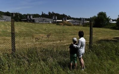 Une femme et un enfant près de la porcherie situé sur le site d'un ancien camp de concentration à Lety, en République tchèque, le 24 juin 2017. (Crédit : Michal Cizek/AFP)