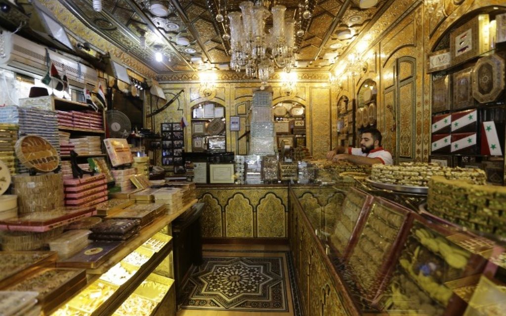 Un employé arrange des pâtisseries syriennes traditionnelles dans un magasin du quartier de Midan à Damas, en Syrie, le 11 septembre 2017 (Crédit : AFP PHOTO / LOUAI BESHARA)