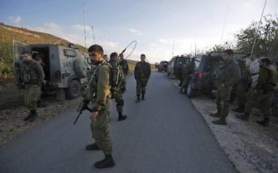 Les soldats israéliens ferment une route à proximité du plateau du Golan pour prévenir l'entrée en Syrie des résidents Druzes après une explosion à la bombe dans le village druze syrien de Hader, le 3 novembre 2017 (Crédit : Jalaa Marey/AFP)