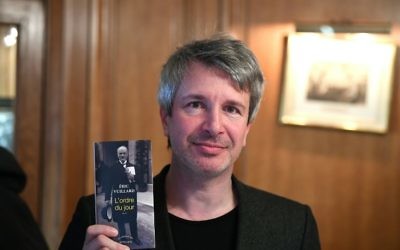 L'écrivaint Eric Vuillard pose avoir son livre après avoir reçu le Prix Goncourt pour L'Ordre du Jour, le 6 novembre2017 au restaurant Drouant à Paris. (Crédit : AFP / Eric FEFERBERG)