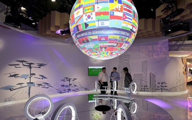 Des visiteurs observent le globe orné de drapeaux durant la COP23, la Conférence de Bonn de 2017 sur les changements climatiques, le 7 novembre 2017 à Bonn, en Allemagne. (Crédit : AFP/Oliver Berg) Des visiteurs observent le globe orné de drapeaux durant la COP23, la Conférence de Bonn de 2017 sur les changements climatiques, le 7 novembre 2017 à Bonn, en Allemagne. (Crédit : AFP/Oliver Berg)