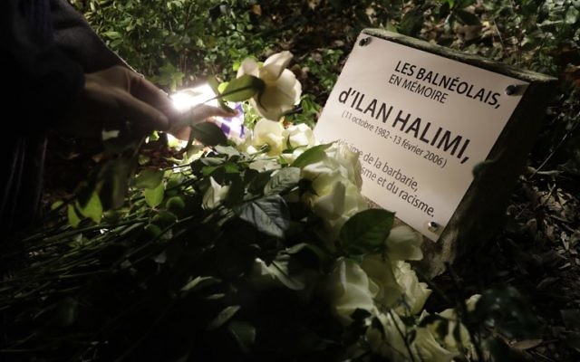 Une personne pose une rose blanche sur la nouvelle plaque  en hommage à Ilan Halimi le 7 novembre 2017 à Bagneux, près de Paris, après une profanation de la plaque commémorative qui a eu lieu le 1er novembre. (Crédit : AFP / Thomas SAMSON)