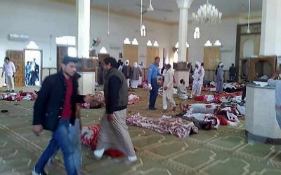 Des Egyptiens marchent autour des cadavres suite à un attentat à l'arme à feu et à la bombe commis dans la mosquée de  Rawda, à à peu-près 40 kilomètres à l'ouest de la capitale d'el-Arish, dans le nord du Sinaï, le 24 novembre 2017 (Crédit : AFP PHOTO / STRINGER)