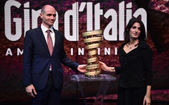 L'ambassadeur d'Israël en Italie, Ofer Sachs, (g) et la maire de Rome, Virginia Raggi, avec le trophée du Giro d'Italia lors de la présentation de la course cycliste du Tour d'Italie 2018, le 29 novembre 2017 à Milan. (Crédit : AFP / MARCO BERTORELLO)
