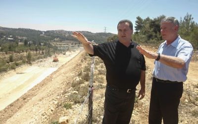 Le ministre des Transports Yisrael Katz, au centre, avec le directeur-général de Netivei Israel Shai Baras, lqui a été ultérieurement arrêté pour népotisme, alors qu'ils inspectaient la construction d'une nouvelle autoroute entre Jérusalem et Tel Aviv, le 12 juin 2013 (Crédit : Flash 90)