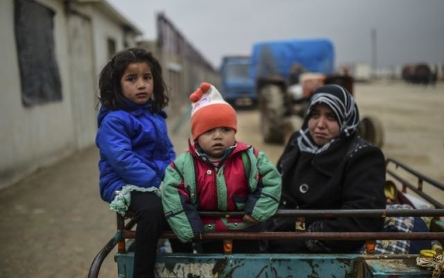 Des enfants réfugiés arrivent à la frontière turque alors que des Syriens fuyant la ville assiégée d'Alep attendent pour passer la frontière, le 6 février 2016 à Bab al-Salama, près de la ville d'Azaz, au nord de la Syrie (Crédit : AFP / Bulent Kilic)