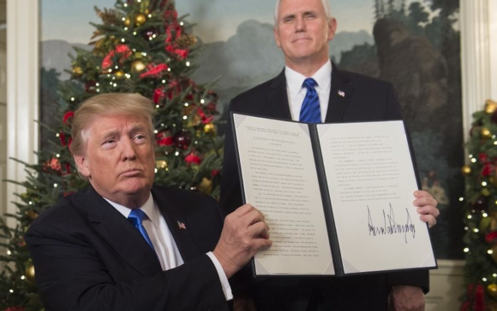 Le président américain Donald Trump tient un mémorandum signé après avoir prononcé son discours concernant Jérusalem depuis la Maison-Blanche, à Washington, le 6 décembre 2017, sous le regard du vice-président américain Mike Pence (Crédit : Saul Loeb / AFP) Le président américain Donald Trump tient un mémorandum signé après avoir prononcé son discours concernant Jérusalem depuis la Maison-Blanche, à Washington, le 6 décembre 2017, sous le regard du vice-président américain Mike Pence (Crédit : Saul Loeb / AFP)