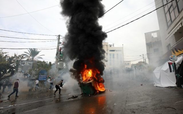 Les forces de sécurité libanaises lancent des gaz lacrymogènes pour disperser les manifestants alors qu'une benne à ordures est en feu lors d'une manifestation devant l'ambassade américaine à Awkar, aux abords de la capitale libanaise Beyrouth, le 10 décembre 2017. (AFP / ANWAR AMRO)