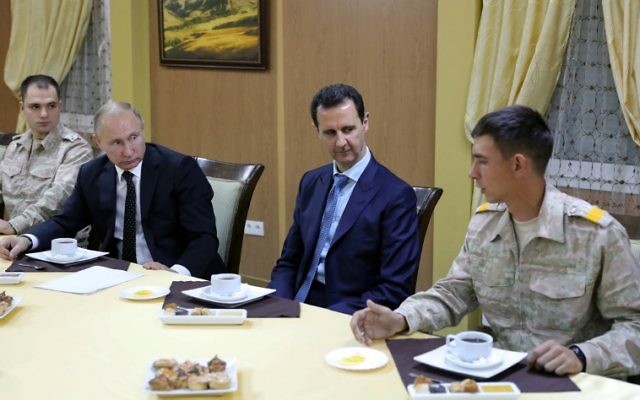 Le président russe Vladimir Poutine et son homologue syrien Bashar el-Assad, avec l'armée, dans la base militaire russe à Hmeimim, dans la province de Latka, le 11 décembre 2017. (Crédit : Mikhail KLIMENTYEV / POOL / AFP) Le président russe Vladimir Poutine et son homologue syrien Bashar el-Assad, avec l'armée, dans la base militaire russe à Hmeimim, dans la province de Latka, le 11 décembre 2017. (Crédit : Mikhail KLIMENTYEV / POOL / AFP)