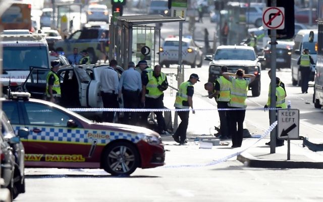 La police et les secouristes sur les lieux où une voiture a percuté délibérément des piétons dans la rue Flinders à Melbourne le 21 décembre 2017 (crédit : AFP PHOTO / Mal Fairclough)