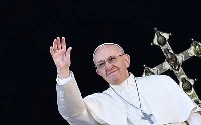 Le pape François salue les fidèles depuis le balcon de la Basilique au Vatican après son traditionnel message "Urbi et Orbi" le 25 décembre 2017. (Crédit : AFP / Andreas SOLARO)