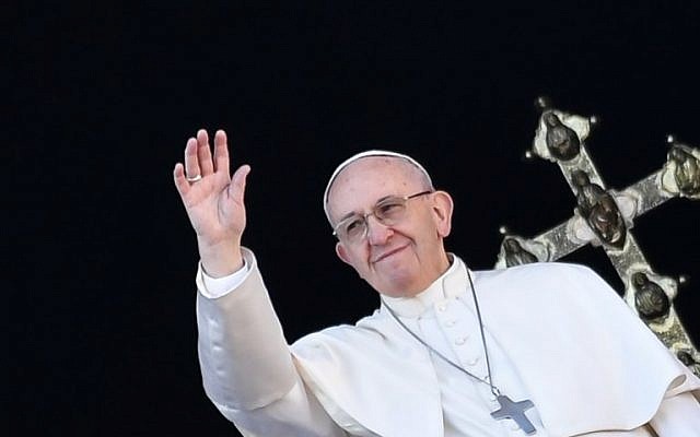 Le pape François salue les fidèles depuis le balcon de la Basilique au Vatican après son traditionnel message "Urbi et Orbi" le 25 décembre 2017. (Crédit : AFP / Andreas SOLARO)