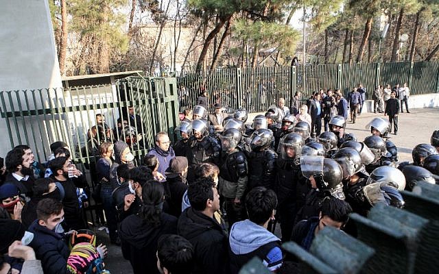 Des étudiants iraniens affrontent la police à l'université de Téhéran durant une manifestation, le 30 décembre 2017 (Crédit : AFP PHOTO / STR) Des étudiants iraniens affrontent la police à l'université de Téhéran durant une manifestation, le 30 décembre 2017 (Crédit : AFP PHOTO / STR)