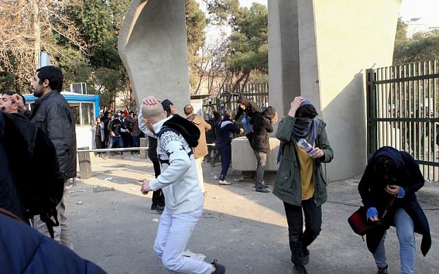 Des étudiants iraniens fuient les gaz lacrymogènes à l'université de Téhéran durant une manifestation, le 30 décembre 2017 (Crédit : AFP PHOTO / STR) Des étudiants iraniens fuient les gaz lacrymogènes à l'université de Téhéran durant une manifestation, le 30 décembre 2017 (Crédit : AFP PHOTO / STR)