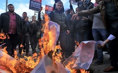Des manifestants palestiniens brûlent des photos du président américain Donald Trump et du Premier ministre Benjamin Netanyahu après la décision de Trump de reconnaître Jérusalem comme capitale d'Israël, dans la ville de Gaza, le 7 décembre 2017 (AFP PHOTO / MOHAMMED ABED)