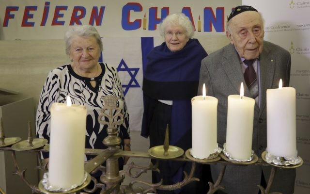 De gauche à droite : Assia Gorban, Marlene Herzberg et Rudolf Rosenberg, survivants de l'Holocauste, assistent à une réception et à l'illumination des bougies de Hanoukka au Centre communautaire juif, à Berlin, en Allemagne, le jeudi 14 décembre 2017 (AP Photo / Michael Sohn)