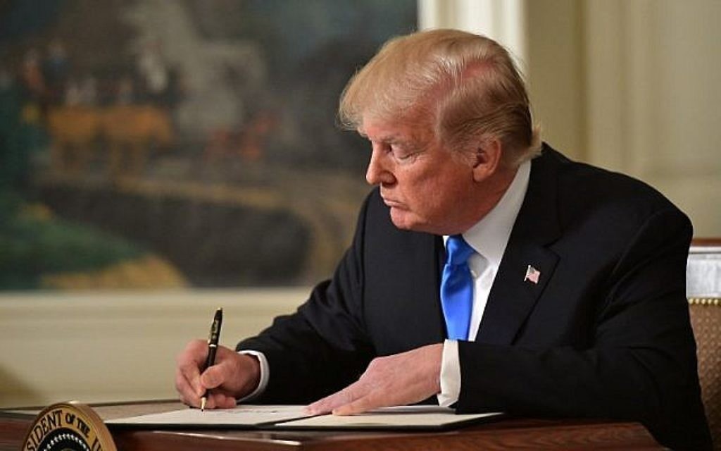 Le président américain Donald Trump signe un mémorandum après avoir prononcé une déclaration sur Jérusalem depuis la Maison-Blanche, à Washington, le 6 décembre 2017 (Saul Loeb / AFP)