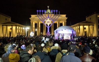 Les gens se tiennent devant une Hannoukia géante devant la Porte de Brandebourg à Berlin, le 6 décembre 2015. (Jorg Carstensen / DPA / AFP)