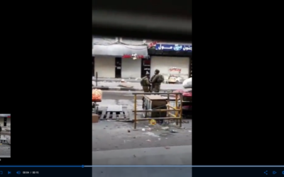 Un soldat israélien vole apparemment un fruit à un vendeur palestinien durant une manifestation violente dans la ville de Hébron, le 10 décembre 2017 (Capture d'écran) Un soldat israélien vole apparemment un fruit à un vendeur palestinien durant une manifestation violente dans la ville de Hébron, le 10 décembre 2017 (Capture d'écran)