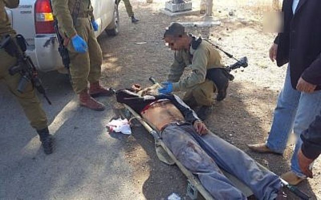 Des soldats de l'armée israélienne s'occupent de Mahmoud Zaal Odeh après qu'il a été blessé par un habitant d'implantation israélien aux abords du village de Qusra le 30 novembre 2017 (Autorisation) Des soldats de l'armée israélienne s'occupent de Mahmoud Zaal Odeh après qu'il a été blessé par un habitant d'implantation israélien aux abords du village de Qusra le 30 novembre 2017 (Autorisation)