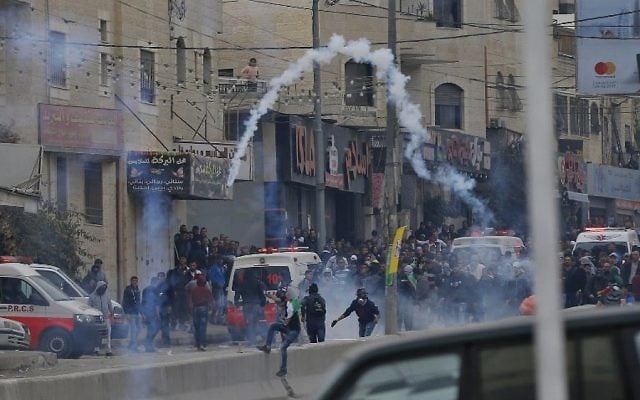 Des manifestants palestiniens affrontent les forces de l’ordre israéliennes près du checkpoint de Qalandiya, en Cisjordanie, le 20 décembre 2017, après la reconnaissance de Jérusalem comme capitale d’Israël par Donald Trump. (Crédit : AFP / ABBAS MOMANI)