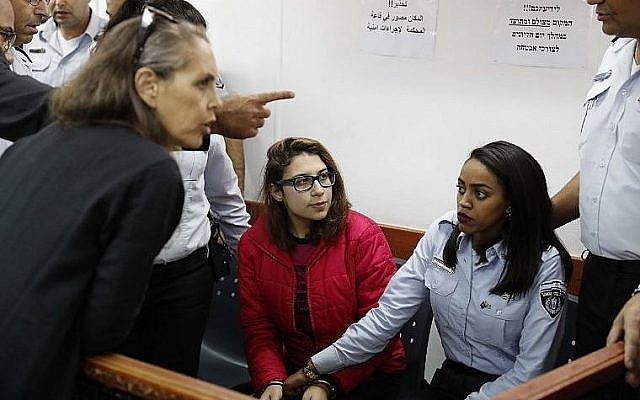Nour Tamimi (C), qui est détenue après une vidéo virale montrant deux membres de sa famille en train d'agresser deux soldats israéliens, dans un tribunal militaire à la prison d'Ofer en Cisjordanie le 28 décembre 2017 (Crédit : Ahmad Gharabli / AFP) Nour Tamimi (C), qui est détenue après une vidéo virale montrant deux membres de sa famille en train d'agresser deux soldats israéliens, dans un tribunal militaire à la prison d'Ofer en Cisjordanie le 28 décembre 2017 (Crédit : Ahmad Gharabli / AFP)