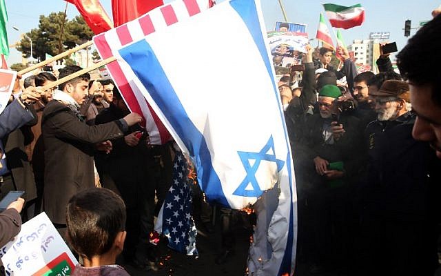 Les manifestants iraniens pro-régime ont brûlé les drapeaux israéliens et américains lors d'un rassemblement en faveur du régime après que les autorités ont déclaré la fin des troubles meurtriers, dans la ville de Mashhad le 4 janvier 2018, (Crédit : PHOTO AFP / NOUVELLES TASNIM / NIMA NAJAFZADEH) Les manifestants iraniens pro-régime ont brûlé les drapeaux israéliens et américains lors d'un rassemblement en faveur du régime après que les autorités ont déclaré la fin des troubles meurtriers, dans la ville de Mashhad le 4 janvier 2018, (Crédit : PHOTO AFP / NOUVELLES TASNIM / NIMA NAJAFZADEH)