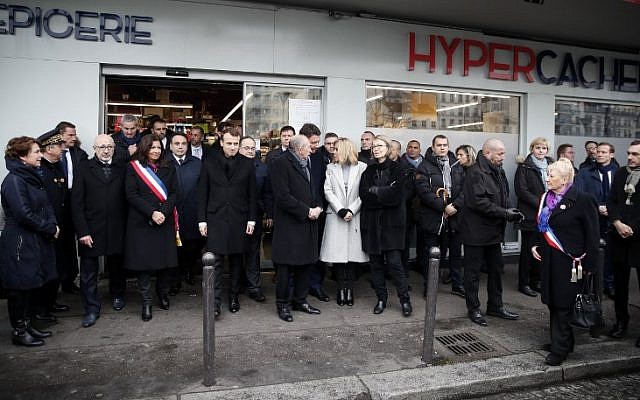 La maire de Paris Anne Hidalgo (4ème g), le président français Emmanuel Macron (5ème g), le ministre français de l'Intérieur Gérard Collomb (6ème), le porte-parole du gouvernement français Benjamin Griveaux (C), la femme du président Brigitte Macron (6ème) rendent hommage lors d'une cérémonie commémorative devant le supermarché Hyper Casher aux victimes du magasin casher qui ont été tuées il y a trois ans par un terroriste islamiste à Paris, le 7 janvier 2018. (Crédit : AFP / POOL / CHRISTIAN HARTMANN) La maire de Paris Anne Hidalgo (4ème g), le président français Emmanuel Macron (5ème g), le ministre français de l'Intérieur Gérard Collomb (6ème), le porte-parole du gouvernement français Benjamin Griveaux (C), la femme du président Brigitte Macron (6ème) rendent hommage lors d'une cérémonie commémorative devant le supermarché Hyper Casher aux victimes du magasin casher qui ont été tuées il y a trois ans par un terroriste islamiste à Paris, le 7 janvier 2018. (Crédit : AFP / POOL / CHRISTIAN HARTMANN)