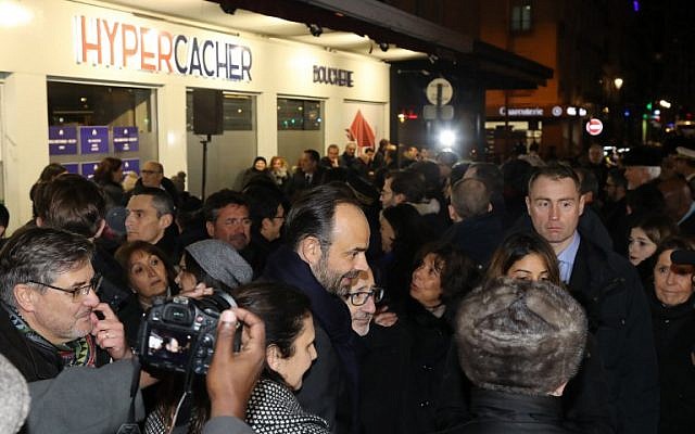 Le Premier ministre français Edouard Philippe entouré des familles des victimes lors d'un hommage aux victimes de la prise d'otage au supermarché HyperCacher à Vincennes, le 9 janvier 2018, organisé par le Crif, à l'occasion du troisième anniversaire de l'attentat. (Crédit : AFP / POOL / JACQUES DEMARTHON) Le Premier ministre français Edouard Philippe entouré des familles des victimes lors d'un hommage aux victimes de la prise d'otage au supermarché HyperCacher à Vincennes, le 9 janvier 2018, organisé par le Crif, à l'occasion du troisième anniversaire de l'attentat. (Crédit : AFP / POOL / JACQUES DEMARTHON)