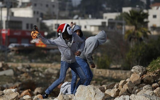 Illustration - Des Palestiniens jettent des cocktails Molotov aux forces israéliennes de sécurité le 18 janvier 2018 au nord de Ramallah, en Cisjordanie (Crédit: AFP PHOTO / ABBAS MOMANI) Illustration - Des Palestiniens jettent des cocktails Molotov aux forces israéliennes de sécurité le 18 janvier 2018 au nord de Ramallah, en Cisjordanie (Crédit: AFP PHOTO / ABBAS MOMANI)