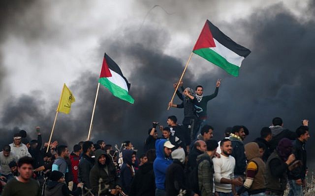 Des manifestants palestiniens agitent des drapeaux nationaux lors d'affrontements avec les forces de sécurité israéliennes dans la banlieue est de la ville de Gaza, près de la frontière avec Israël, le 12 janvier 2018. (AFP PHOTO / MOHAMMED ABED) Des manifestants palestiniens agitent des drapeaux nationaux lors d'affrontements avec les forces de sécurité israéliennes dans la banlieue est de la ville de Gaza, près de la frontière avec Israël, le 12 janvier 2018. (AFP PHOTO / MOHAMMED ABED)