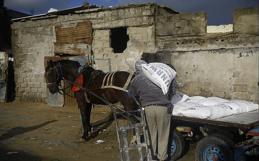 Un Palestinien remplit sa carriole d'aide alimentaire aux abords du centre de distribution des Nations unies à Gaza, le 28 janvier 2018 (Crédit : AFP Photo/Mohammed Abed) Un Palestinien remplit sa carriole d'aide alimentaire aux abords du centre de distribution des Nations unies à Gaza, le 28 janvier 2018 (Crédit : AFP Photo/Mohammed Abed)