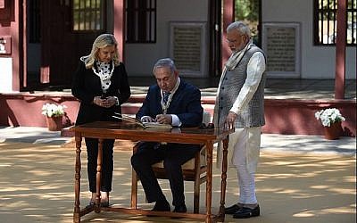 Le Premier ministre Benjamin Netanyahu (C) signe un livre d'or avec son épouse Sara Netanyahu et le Premier ministre indien Narendra Modi lors d'une visite à l'ashram de Gandhi à Ahmedabad le 17 janvier 2018. (AFP Photo / Sam Panthaky)