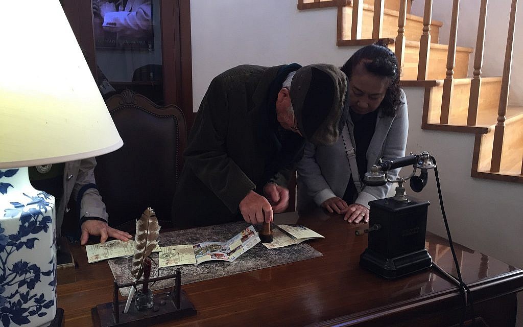 A Yaotsu, au Japon, en novembre 2010, des visiteurs japonais estampillent un passeport avec 'l'estampille de Sugihara' au musée du mémorial Sugihara (Crédit : Amanda Borschel-Dan/Times of Israel)