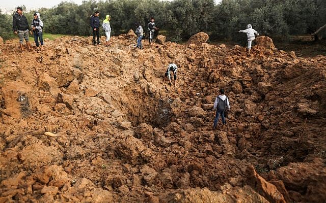 Les Palestiniens inspectent le site d'une frappe aérienne israélienne à Gaza le 18 février 2018 (Crédit : AFP / MAHMUD HAMS) Les Palestiniens inspectent le site d'une frappe aérienne israélienne à Gaza le 18 février 2018 (Crédit : AFP / MAHMUD HAMS)