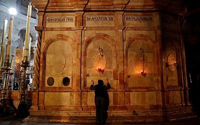 Un fidèle chrétien prie dans l'église du Saint-Sépulcre de Jérusalem après sa réouverture, le 28 février 2018 (Crédit : THOMAS COEX / AFP) Un fidèle chrétien prie dans l'église du Saint-Sépulcre de Jérusalem après sa réouverture, le 28 février 2018 (Crédit : THOMAS COEX / AFP)
