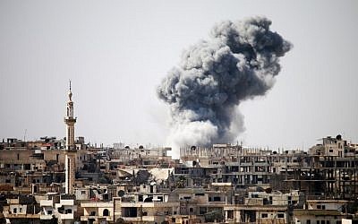 Photo d’illustration : De la fumée apparait au loin après les frappes aériennes signalées sur la ville de Daraa, dans le sud de la Syrie, le 22 février 2017 (Mohamad Abazeed / AFP)