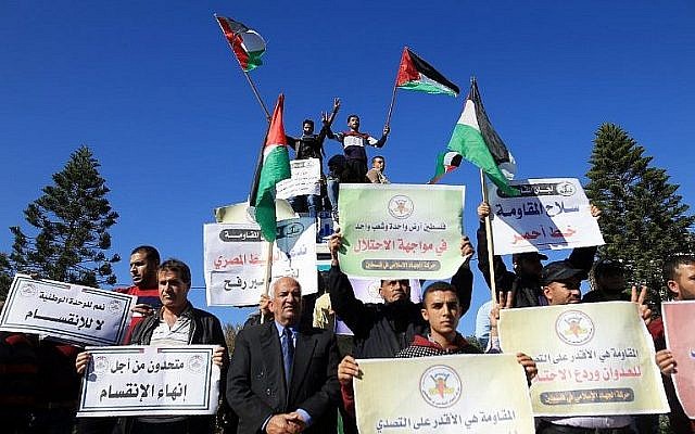 Des Palestiniens brandissent le drapeau national durant une manifestation à Gaza, le 3 décembre 2017, en soutien aux pourparlers de réconciliation entre le Hamas et le Fatah (Crédit : AFP/Mohammed Abed)