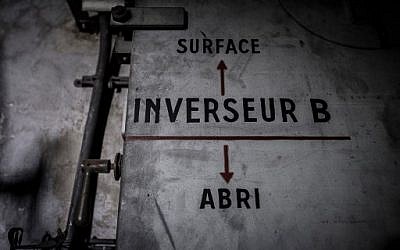 Cette photo prise le 23 janvier 2018 montre un panneau sur une porte indiquant le bunker (flèche pointant vers le bas) et la surface (flèche pointant vers le haut) d'un bunker de la Seconde Guerre mondiale situé sous la Gare de l'Est dans la capitale française Paris. / PHOTO AFP / Philippe LOPEZ