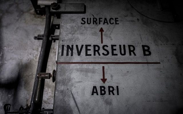 Cette photo prise le 23 janvier 2018 montre un panneau sur une porte indiquant le bunker (flèche pointant vers le bas) et la surface (flèche pointant vers le haut) d'un bunker de la Seconde Guerre mondiale situé sous la Gare de l'Est dans la capitale française Paris. / PHOTO AFP / Philippe LOPEZ
