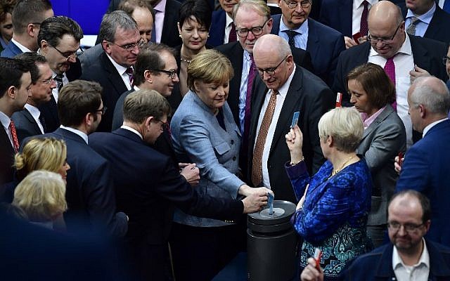 La chancelière allemande et leader du parti de l'Union chrétienne-démocrate (CDU), Angela Merkel (au centre), vote à la chambre basse allemande du Bundestag à Berlin le 1er février 2018 lors du vote du l'adoption d'une loi restreignant le regroupement familial des réfugiés en Allemagne (Crédit : PHOTO AFP / Tobias SCHWARZ