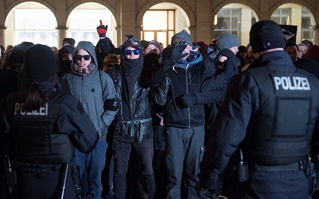 Des policiers font face à des contre-manifestants de gauche qui protestent contre une manifestation d'extrême droite de l'AfD sur l'ancienne place du marché de Dresde, le 13 février 2018. (Crédit : Sebastian Kahnert / dpa / AFP)
