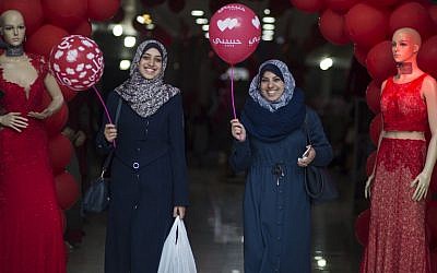 Des Palestiniennes tiennent des ballons le jour de la Saint Valentin, le 14 février 2018 (Crédit : / AFP PHOTO / MOHAMMED ABED)
