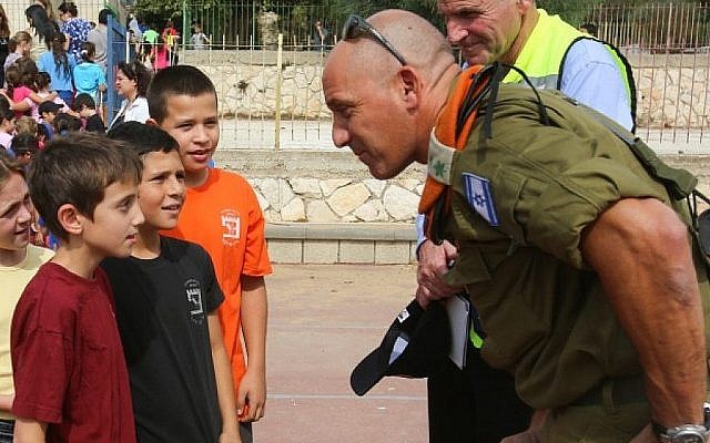 Un officier du Front intérieur parle avec des élèves pendant un exercice d'urgence dans une école israélienne au mois d'octobre 2012 (Crédit : Oren Nahshon/Flash90) Un officier du Front intérieur parle avec des élèves pendant un exercice d'urgence dans une école israélienne au mois d'octobre 2012 (Crédit : Oren Nahshon/Flash90)
