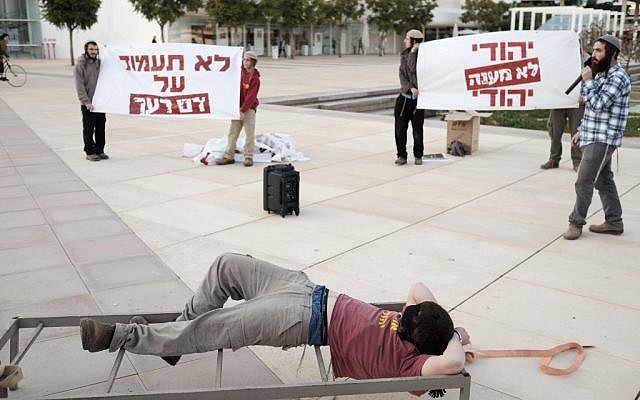 Des militants de droite assistent à une manifestation à Tel Aviv, mettant en scène des tortures présumées par le Shin Bet contre des présumés terroristes juifs (Crédit : Tomer Neuberg/Flash90) Des militants de droite assistent à une manifestation à Tel Aviv, mettant en scène des tortures présumées par le Shin Bet contre des présumés terroristes juifs (Crédit : Tomer Neuberg/Flash90)