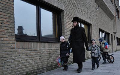 Un père ultra-orthodoxe emmène ses enfants à l'école Jesode Hatorah d'Anvers (Photo d'illustration :  Cnaan Liphshiz/JTA)