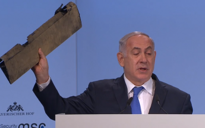 Le Premier ministre Benjamin Netanyahu tient un morceau du drone iranien abattu dans l'espace aérien israélien au troisième jour de la 54e conférence de Munich sur la sécurité organisée à l'hôtel Bayerischer Hof, dans le sud de l'Allemagne, le 28 février 2018 (Capture d'écran)