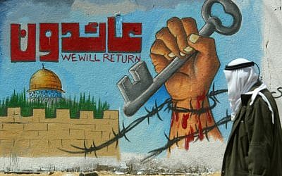 Un Palestinien marche devant une fresque murale appelant au retour des réfugiés palestiniens (Crédit :  Abed Rahim Khatib/Flash90)